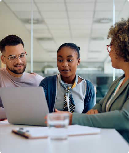Deux femmes et un homme devant un ordinateur portable.