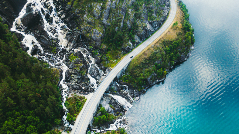 Vue aérienne de la route de montagne avec voiture, mer et cascade