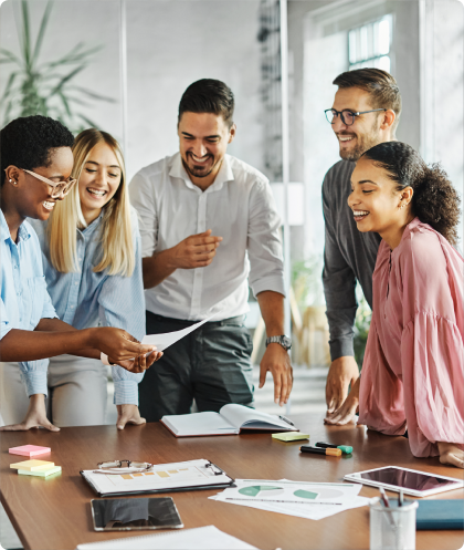 Cinq jeunes autour d'une table travaillant en rigolant.