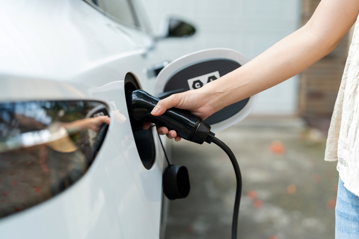 femme chargeant une voiture électrique