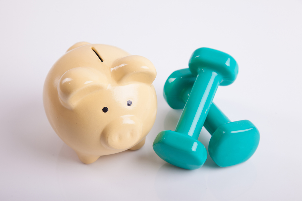 Tirelire et haltères représentant l’épargne et l’effort financier.